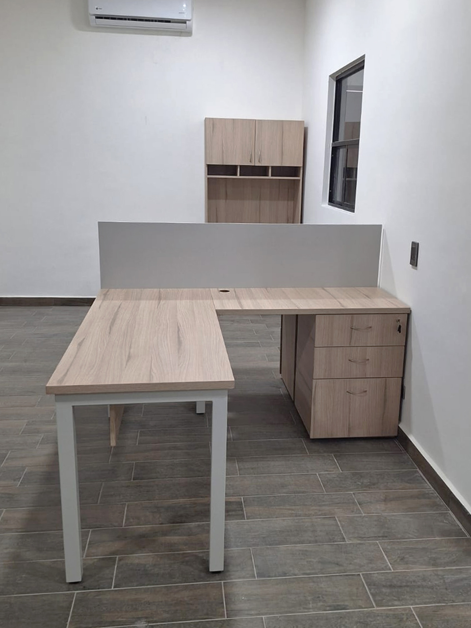 Instalación de áreas de trabajo, módulos en «L», librero a piso y cocineta.